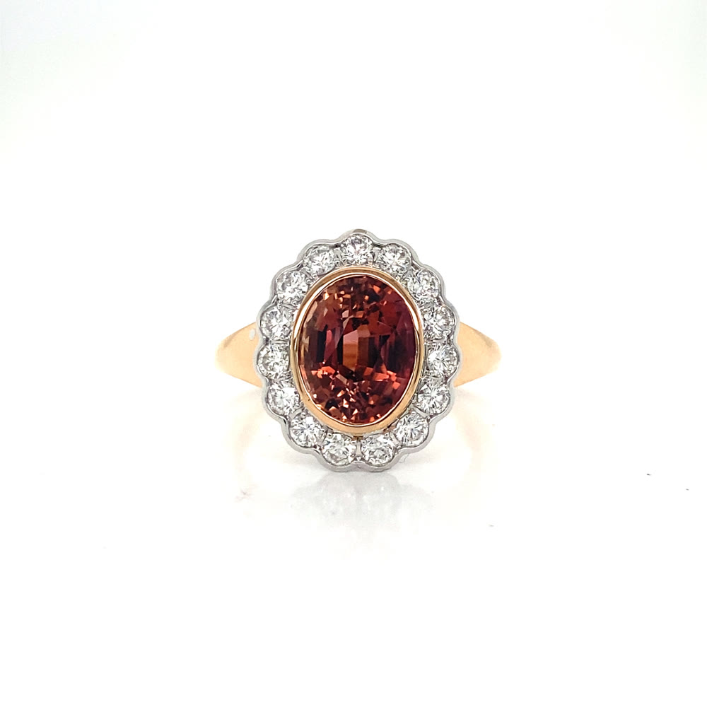 A warm orange stone ring with a scalloped halo and gold band